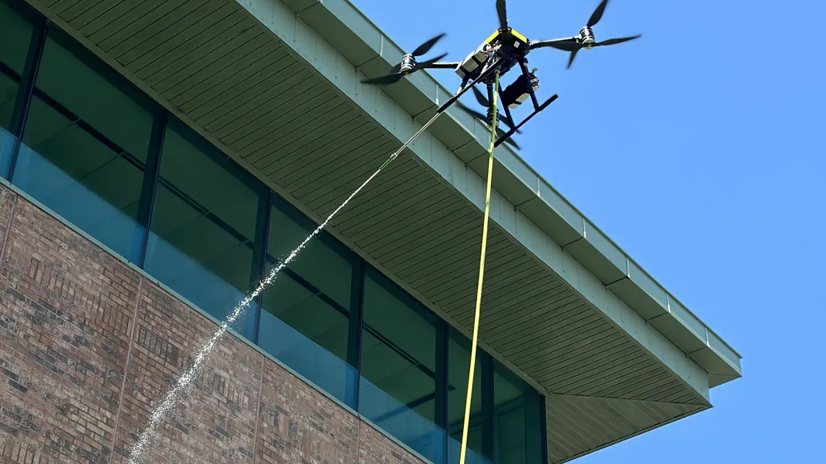 Cleaning aircraft working beside a commercial building exterior