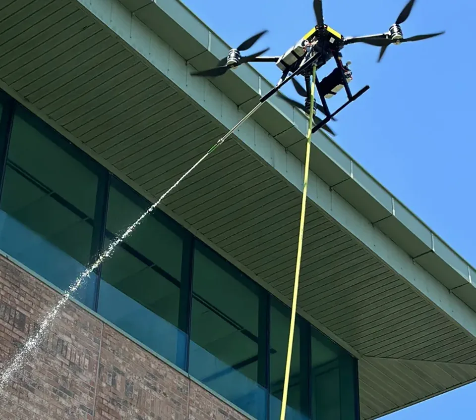 Cleaning aircraft applying a controlled exterior wash beside a building